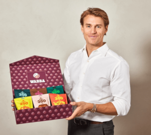 Kristian K. Fredheim smiler mens han viser frem produktet til Wabba